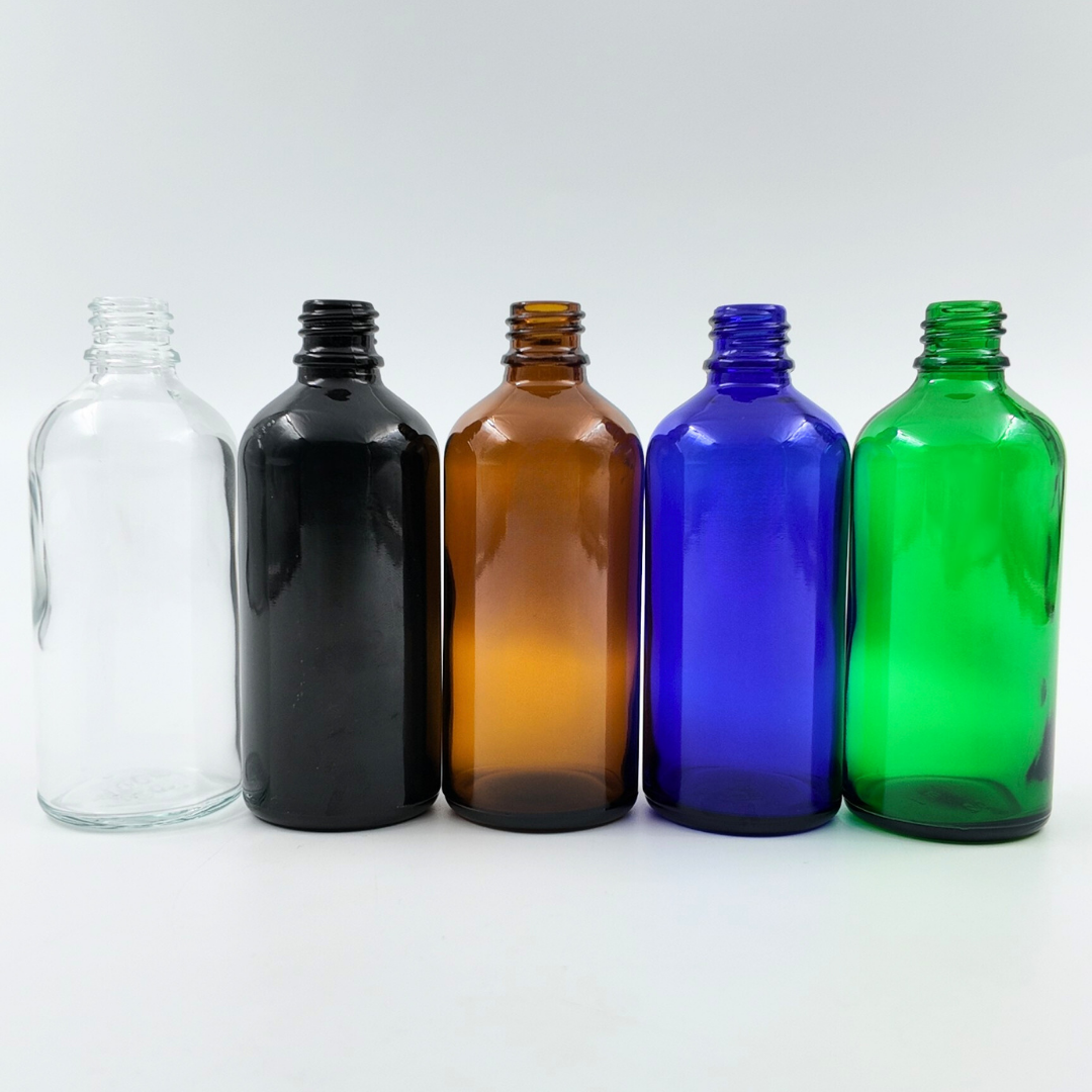 Set of 100ml glass bottles in clear, black, amber, blue, and green arranged side by side on a white background.