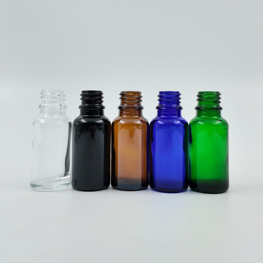 Set of 20ml glass bottles in clear, black, amber, blue, and green arranged side by side on a white background.