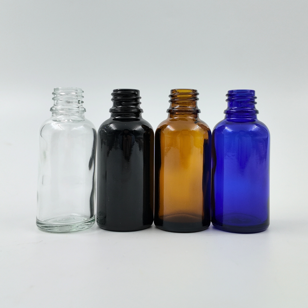 Set of four 30ml glass bottles in clear, black, amber, and blue arranged side by side on a white background.