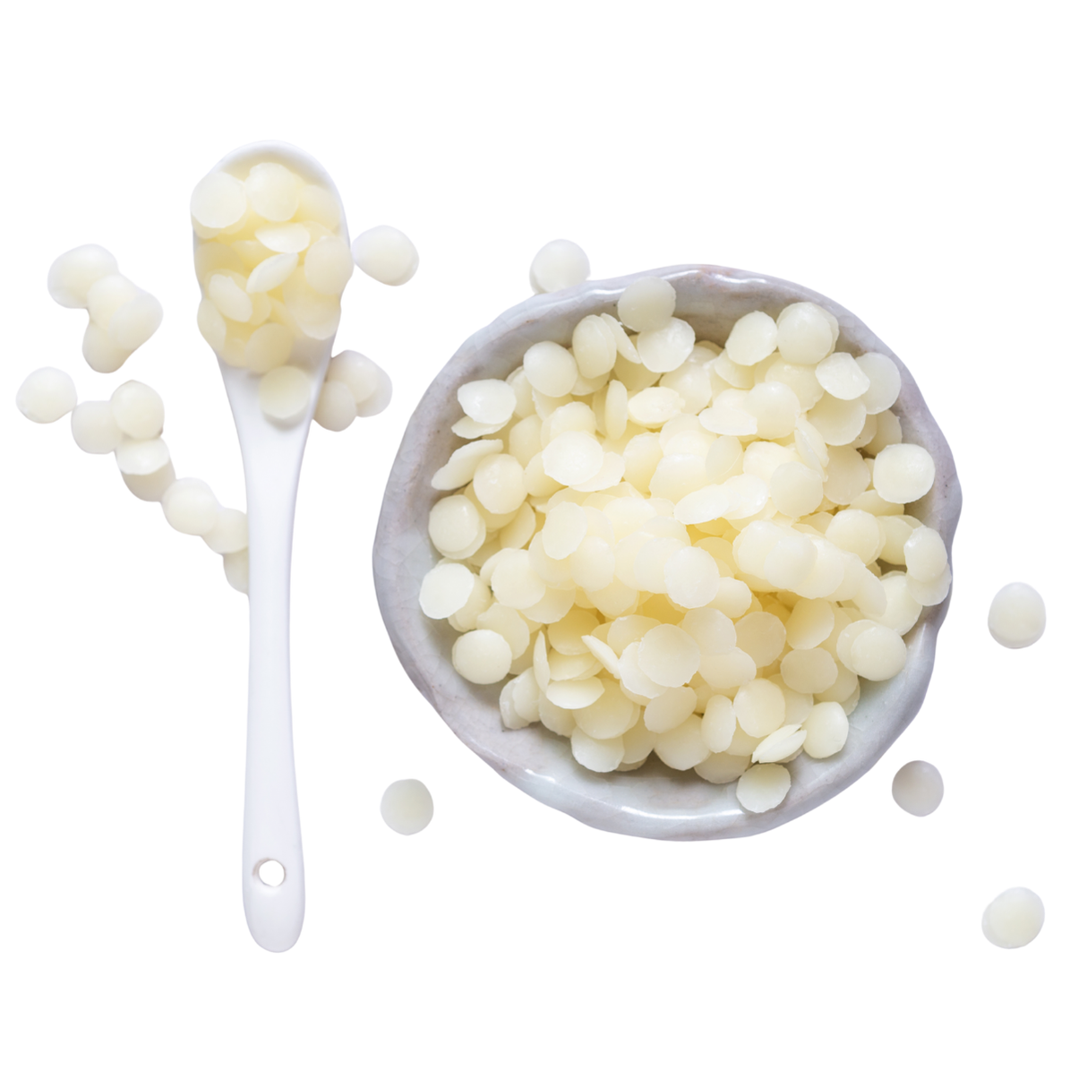 White wax beads in a bowl with a spoon on a white background