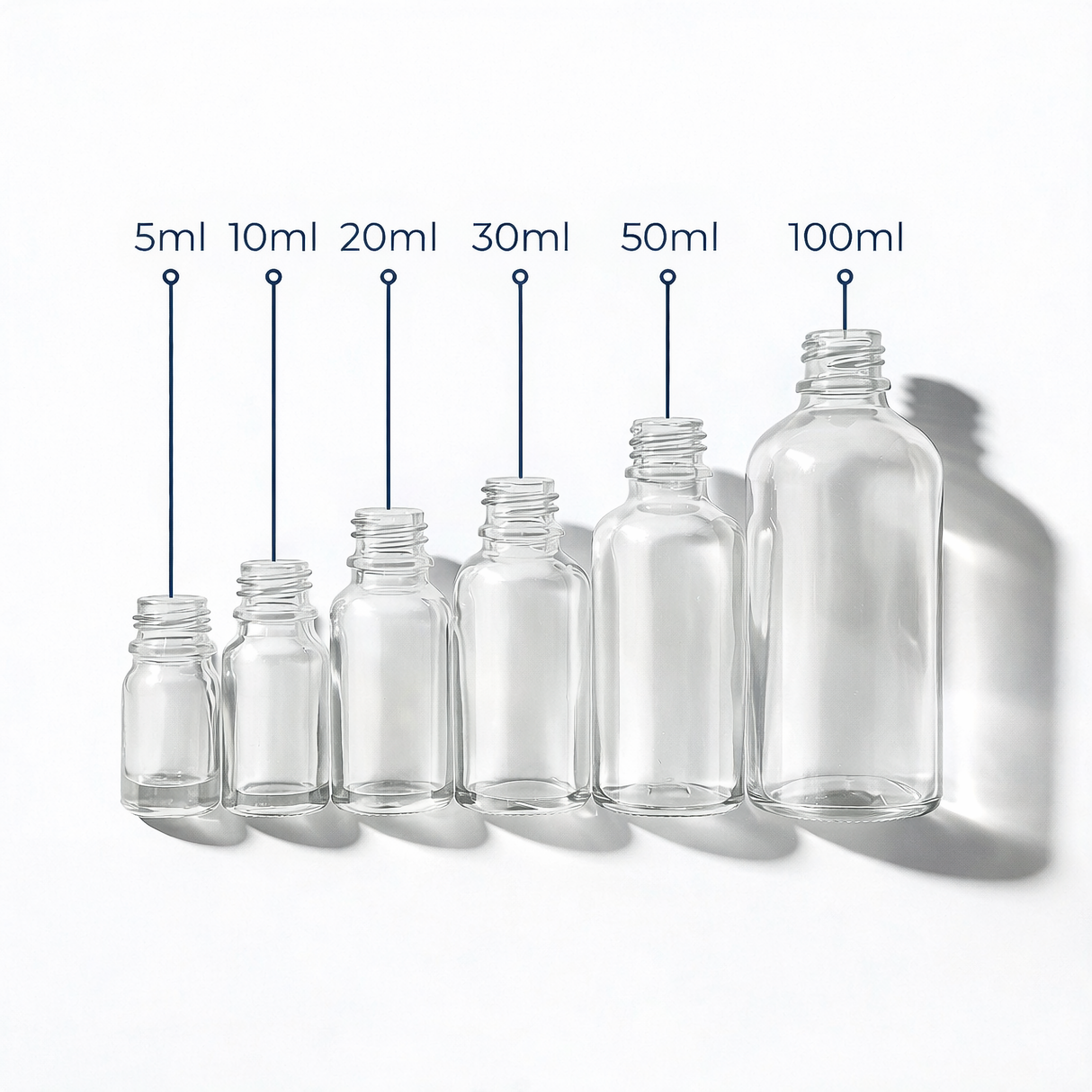 Collection of clear glass dropper bottles, empty cosmetic packaging for serums, oils and skincare formulations