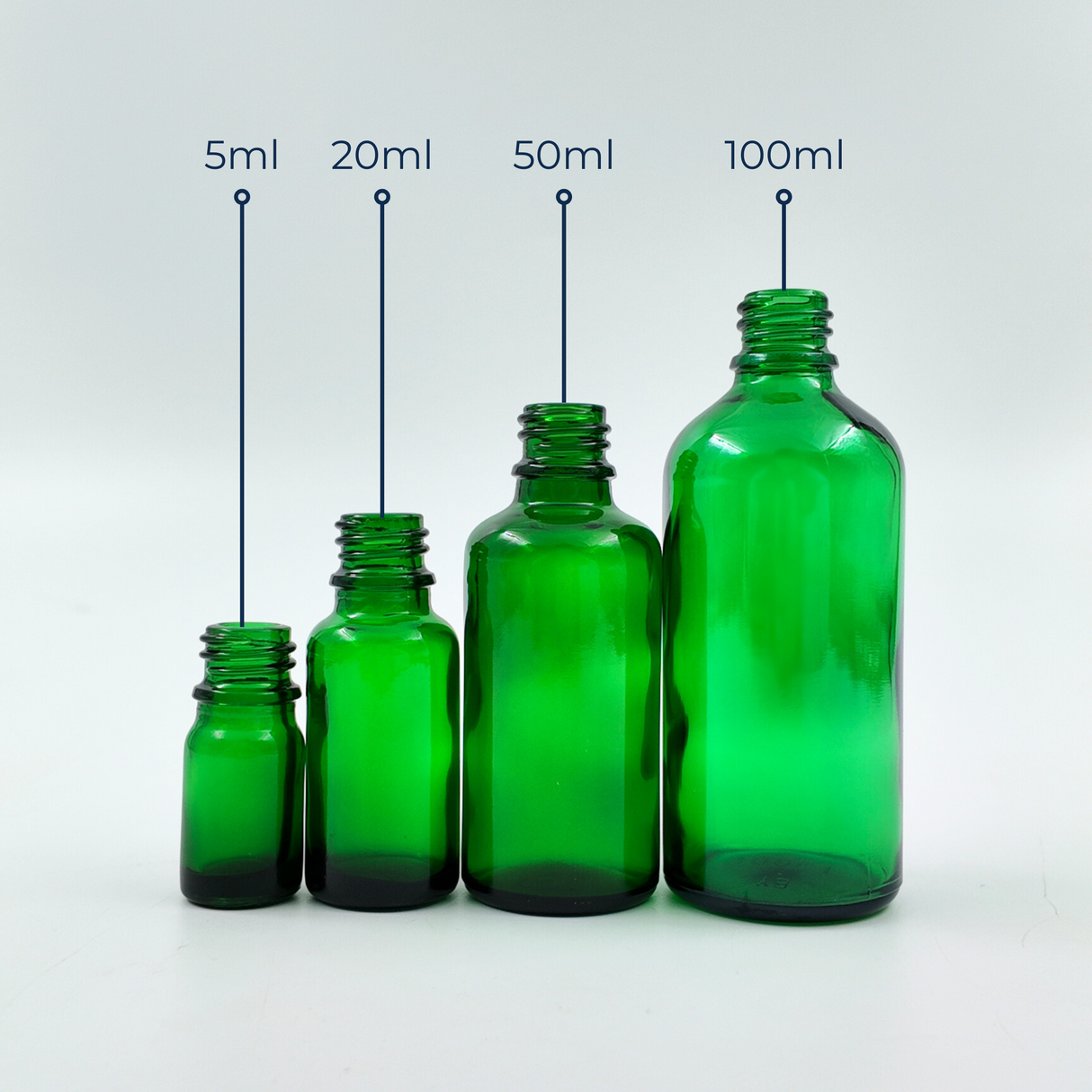 Set of green glass bottles in assorted sizes displayed together