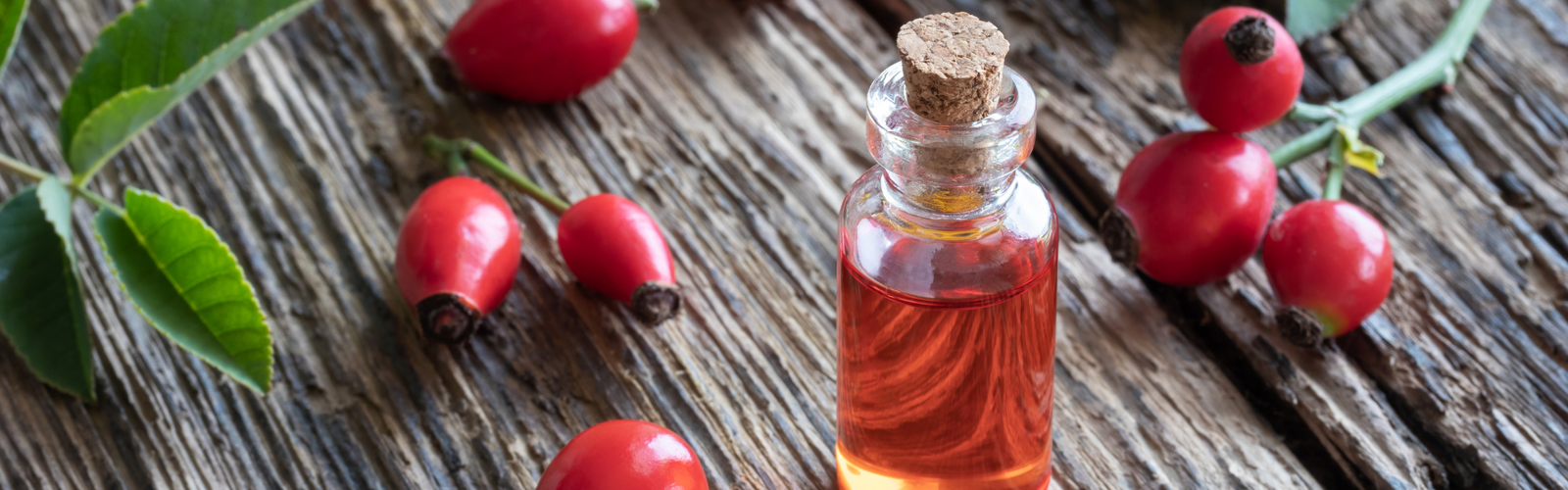 Rosehip Oil bottle surrounded by rosehip seeds