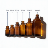 collection of amber glass dropper bottles, empty cosmetic packaging for serums, oils and skincare formulations