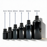 Collection of black glass dropper bottles, empty cosmetic packaging for serums, oils and skincare formulations