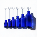 Collection of blue glass dropper bottles, empty cosmetic packaging for serums, oils and skincare formulations