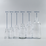 Set of clear glass bottles in assorted sizes displayed together