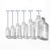 Collection of clear glass dropper bottles, empty cosmetic packaging for serums, oils and skincare formulations