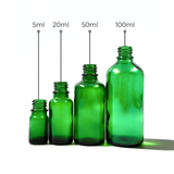 Collection of green glass dropper bottles, empty cosmetic packaging for serums, oils and skincare formulations