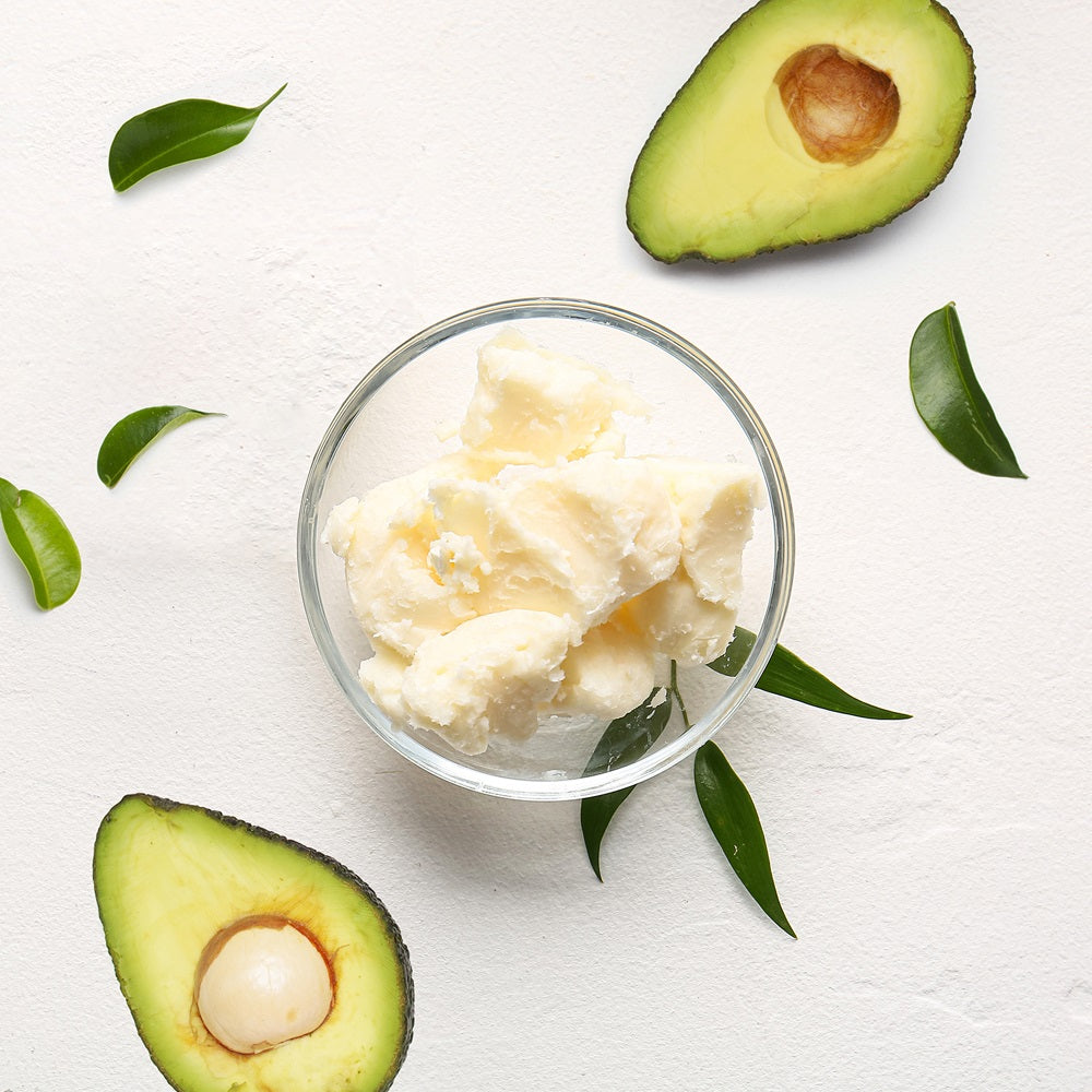 Top View Of Avocado Butter In Glass Bowl Sorrounded By Sliced Avocado And Leaves | Bulk Cosmetic Butters | Brightpack Raw Materials